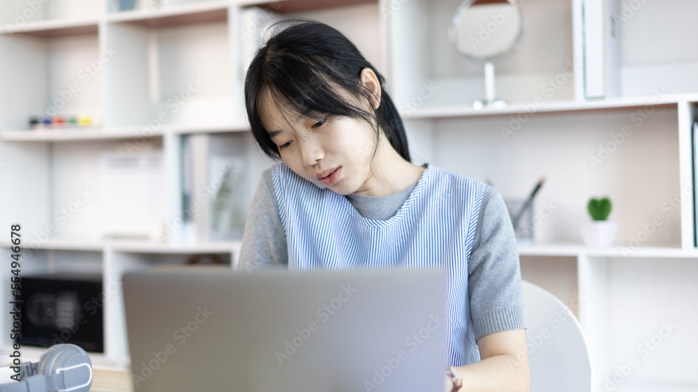 Asian female worker talking on phone and working on laptop with smiling face, Office staff work and telephone conversations, Take notes for reminders, Business conversation over the phone. Asian female worker talking on phone and working on laptop with smiling face, Office staff work and telephone conversations, Take notes for reminders, Business conversation over the phone.