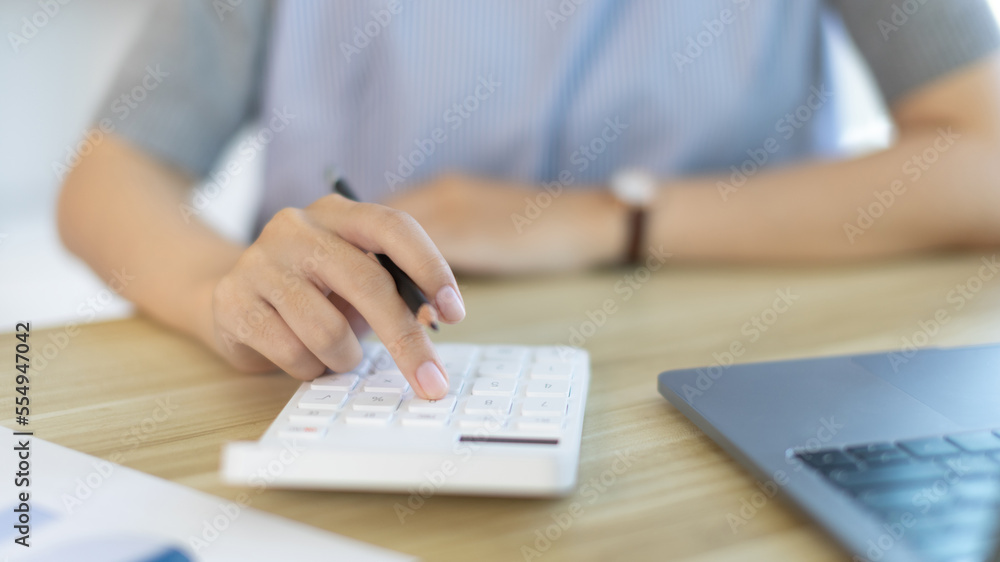 Businesswoman presses a calculator to calculate earnings and analyze company earnings in his private office, Information in finance and accounting, Company performance and revenue. Businesswoman presses a calculator to calculate earnings and analyze company earnings in his private office, Information in finance and accounting, Company performance and revenue.