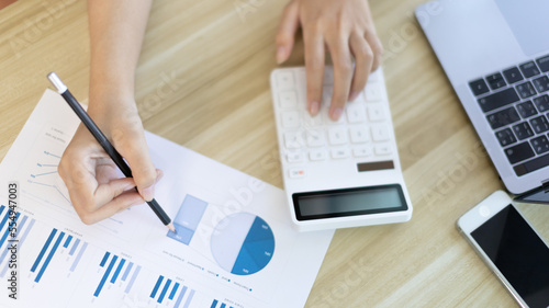 Asian businesswoman sitting and analyzing company financial data, Using laptops and data graphs to work, Online communication , Tax, Vat, Work for home, Social distancing, Work on the internet.