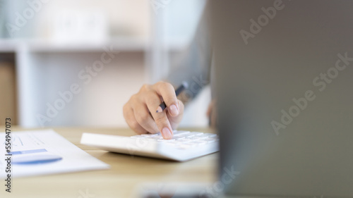 Businesswoman presses a calculator to calculate earnings and analyze company earnings in his private office, Information in finance and accounting, Company performance and revenue.