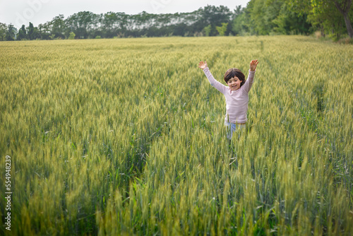 girl with short hair in pink top run happily in wheat field