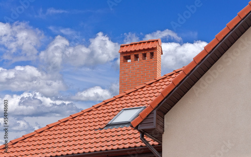 house with a roof from a red shingles with a pipe