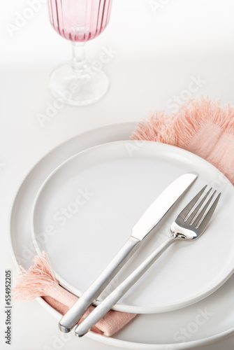 Empty white plate with cutlery on white background. Beautiful  table setting. Selective focus.