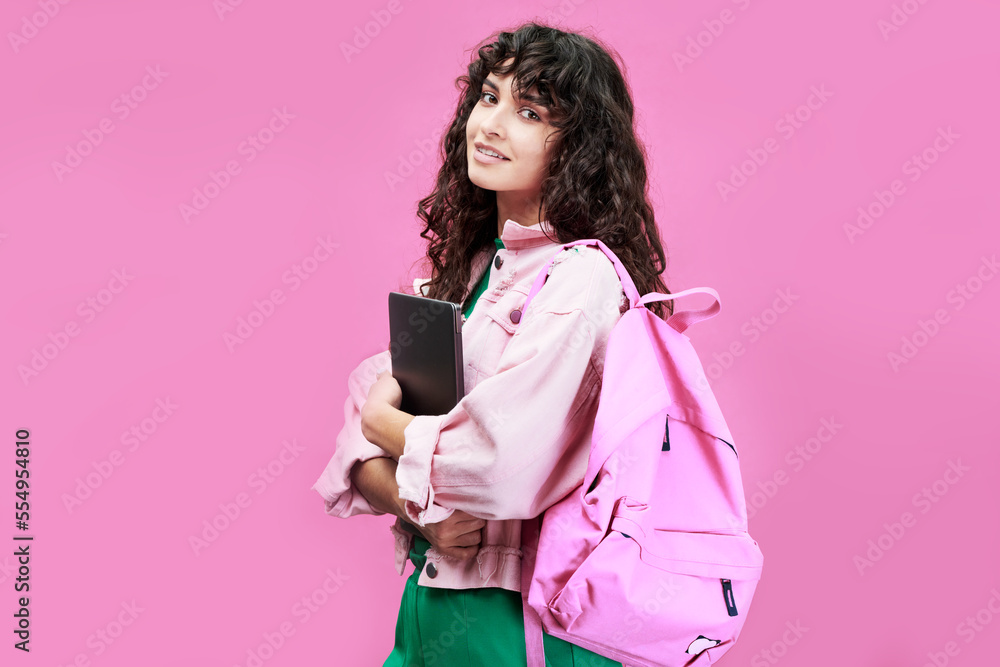Clever female student of college or highschool wearing denim jacket standing in front of camera against pink background Clever female student of college or highschool wearing denim jacket standing in front of camera against pink background