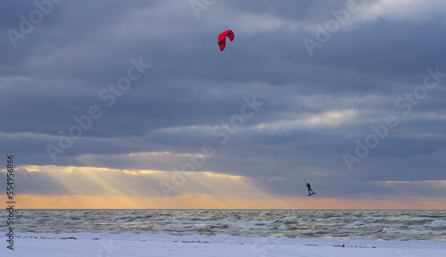 Kite surf in flight in winter. Sunset sky.