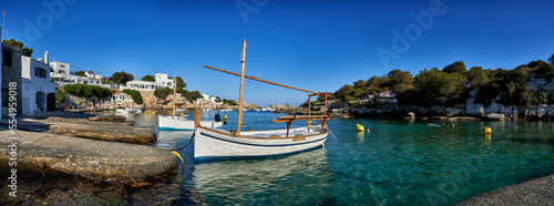 Panorama of small boats moored in the Mediterranean cove of Cala Alcaufar in Menorca. photo