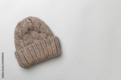 Grey winter hat on color background. Top view