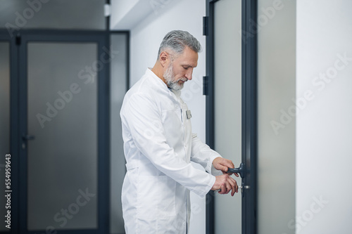 Mature male doctor locking his office