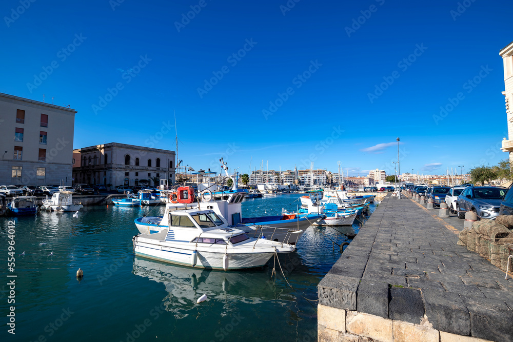 sail boats and pleasure boats in old port, seafront of Ortygia (Ortigia) Island in Syracuse (Siracusa), Sicily, Italy