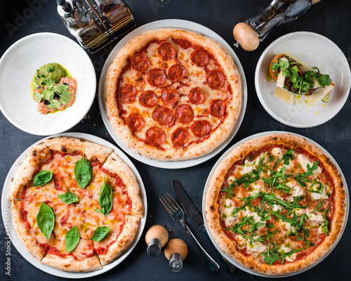 Italian food pizza pizza with pepperoni, mozzarella cheese, tomato sauce, arugula, basil, bruschetta with beef, capers, cherry tomatoes, parmesan, parsley and salmon ceviche with caviar and onion.