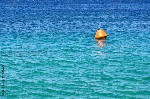 Orange buoy floating on the sea as a warning to ships. No people. Copy space.