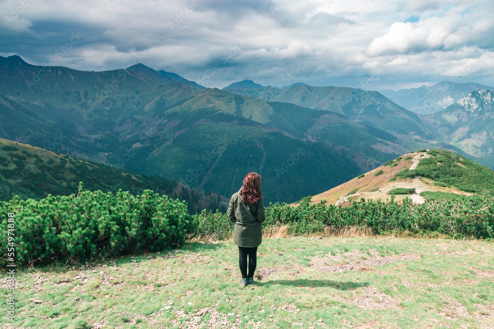 Brunette girl on the background of landscape and green mountains