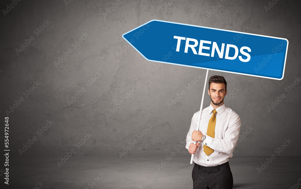 Young business person in casual holding road sign Young business person in casual holding road sign
