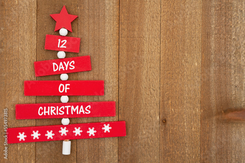 12 days of Christmas message on a Christmas tree on weathered wood