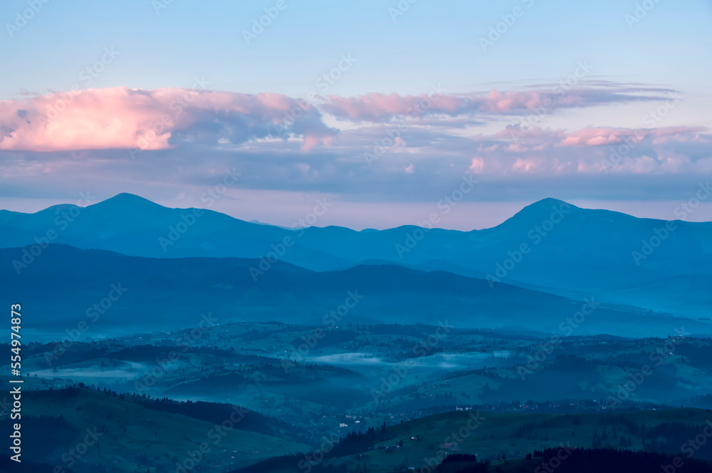 Silhouettes of mountain ranges in the early morning and pink clouds. soft focus. Carpathian mountains.
