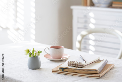 Home desk with notepad and coffee cup.