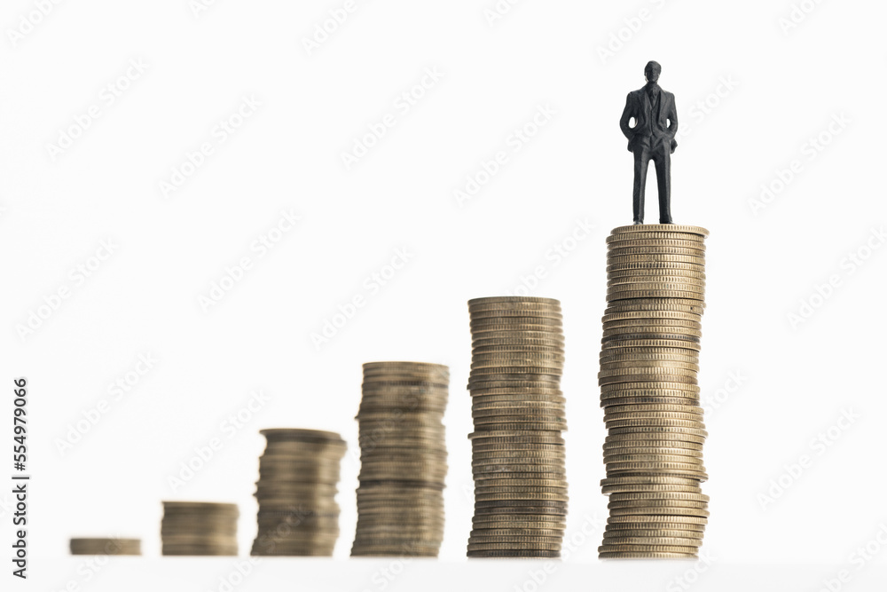 Businessman standing on stack of growing coins