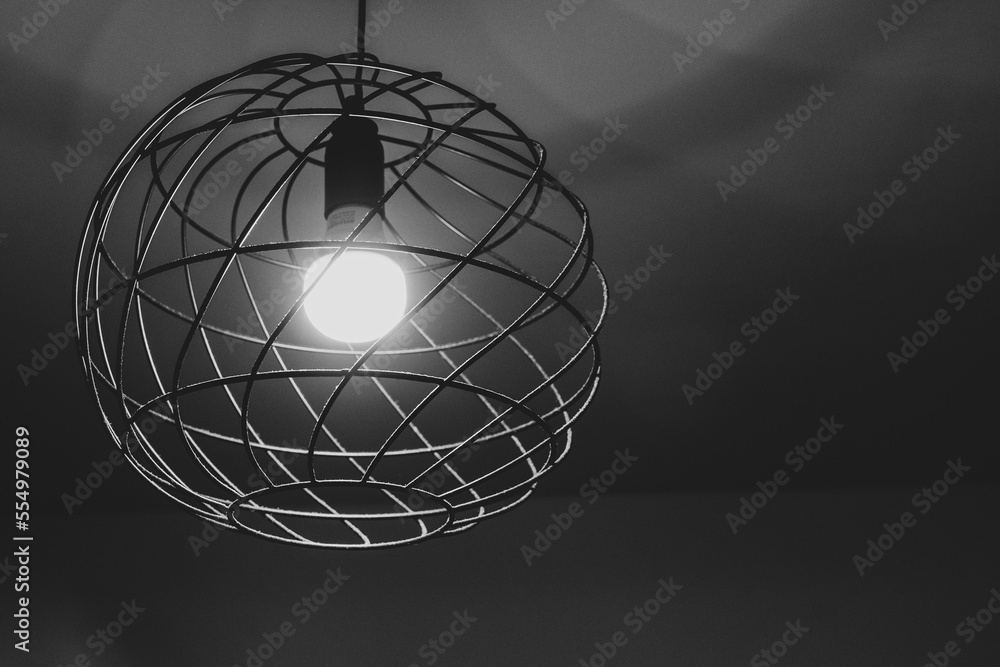 Naklejka premium Side view of a metal ring shape lamp shade with glowing light bulb in the center