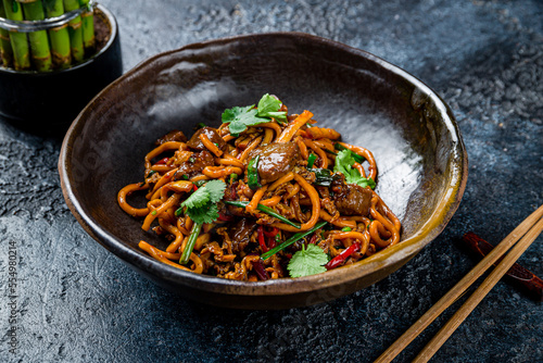 egg noodles with beef on dark stone table, Chinese cuisine