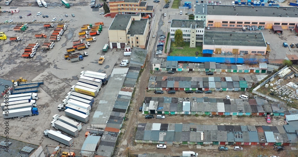 Minsk, Belarus - 10.10.2022: Transport company from above. Mass truck parking. Garages and car repair points. Industrial zone.