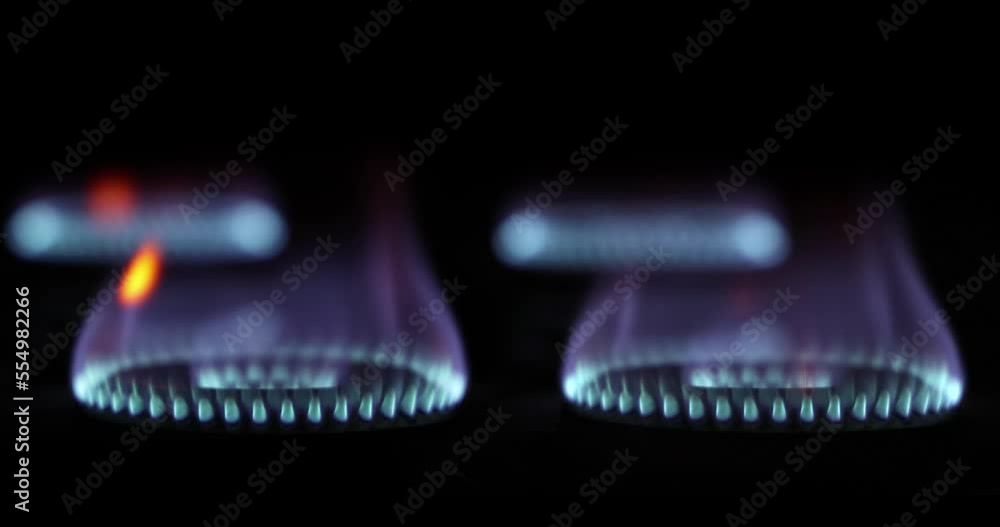 Fire igniting on a kitchen gas stove. Blue flame of gas slowly igniting