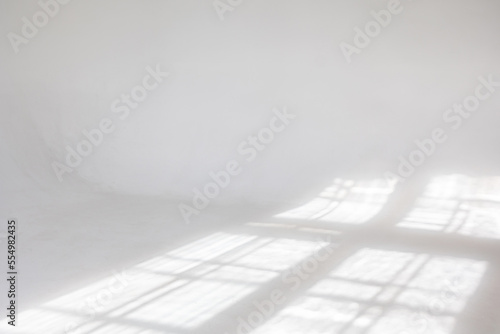 Clear white cyclorama. Light background with sun light and shadows. Plain wall empty photo studio. . High quality photo