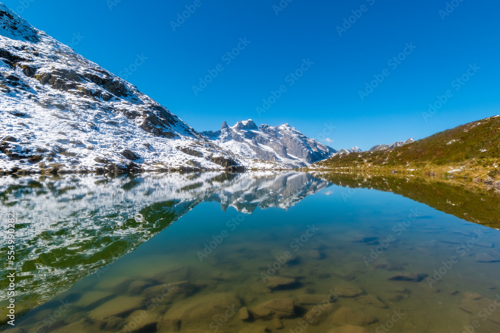 calm tarn with the reflections of the surrounding peaks (Tobelsee, Vorarlberg, Austria)