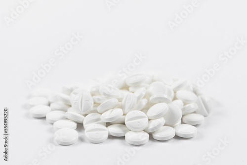 many white round medical tablets for humans and animals, medicinal antibiotics pills medicine closeup