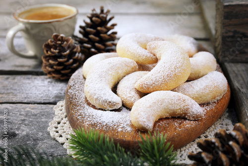 Vanillekipfer cookies. Almond crescents Christmas cookies, powdered sugar dressing, cup of coffee,  new year decoration