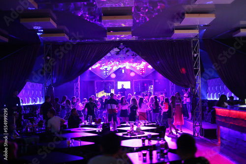 people in a nightclub dance, relax, have fun, DJ plays, light music, rest in a rich way