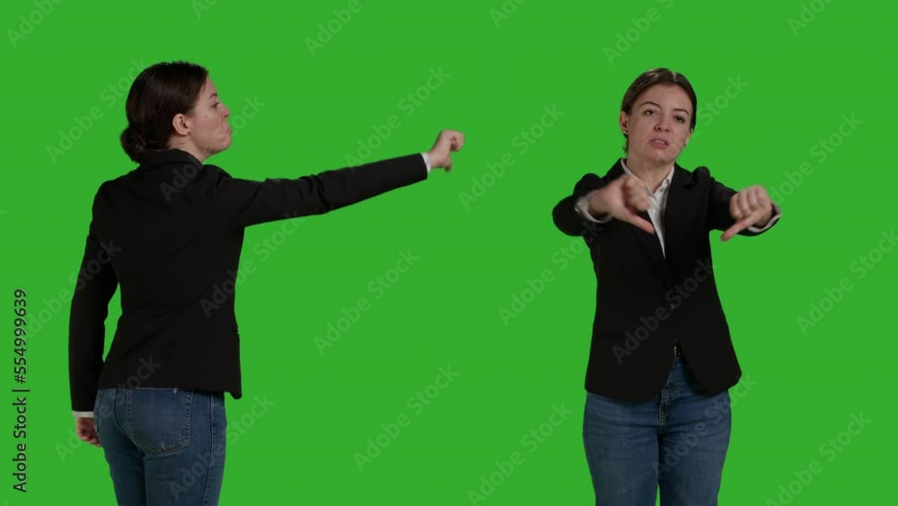 Close up of company worker doing thumbs down sign in studio, showing dislike and negative gesture. Businesswoman with office suit expressing disapproval and disagreement on camera. Close up of company worker doing thumbs down sign in studio, showing dislike and negative gesture. Businesswoman with office suit expressing disapproval and disagreement on camera.