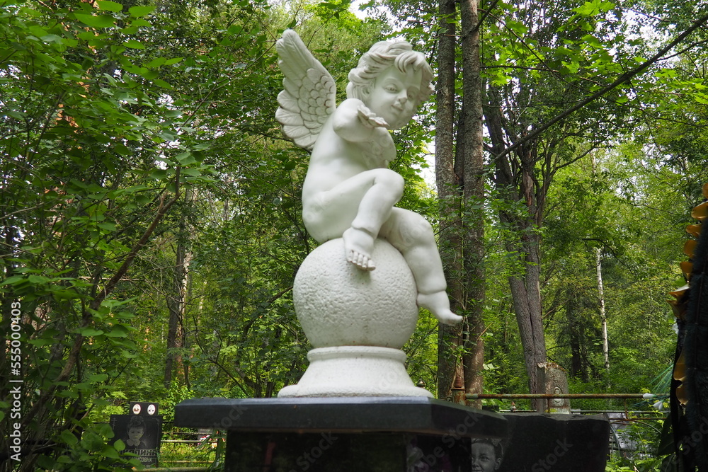 Angel in the cemetery monument at the grave of a child sculpture in the form of an angel