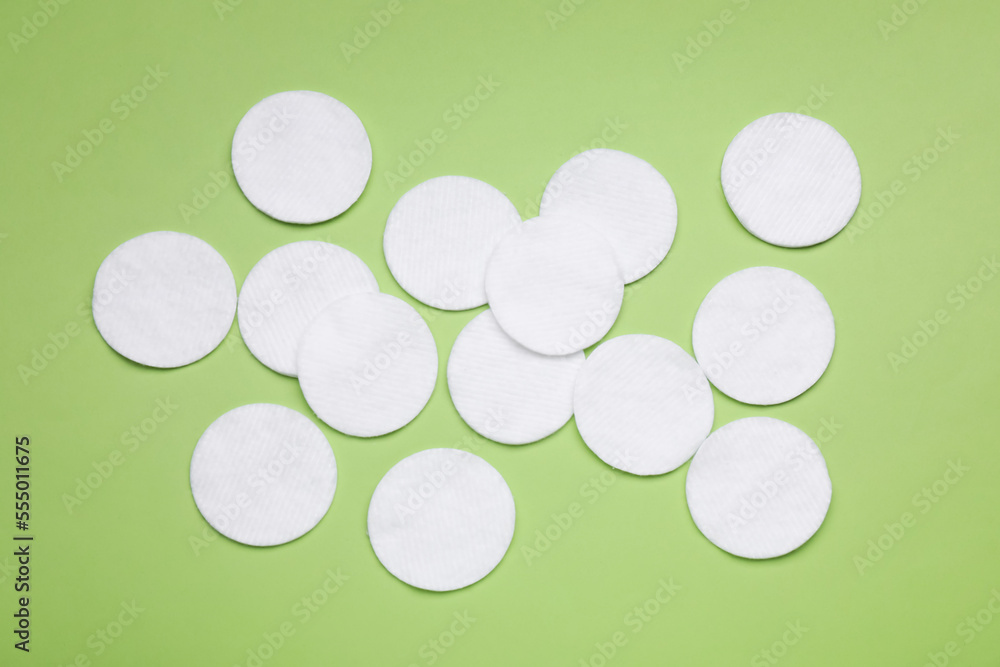 Many cotton pads on green background, flat lay Many cotton pads on green background, flat lay