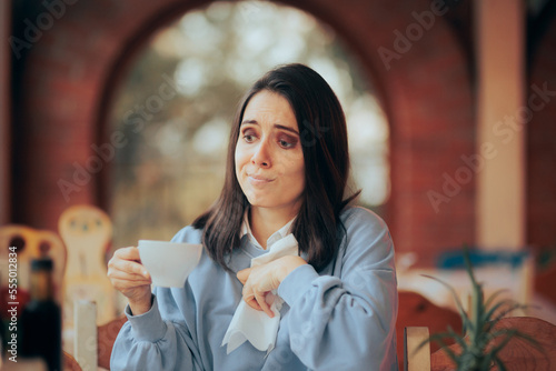 Unlucky Woman Staining her Blouse with Coffee in a Restaurant. Lady having an incident with her teacup spilling all over 
 photo