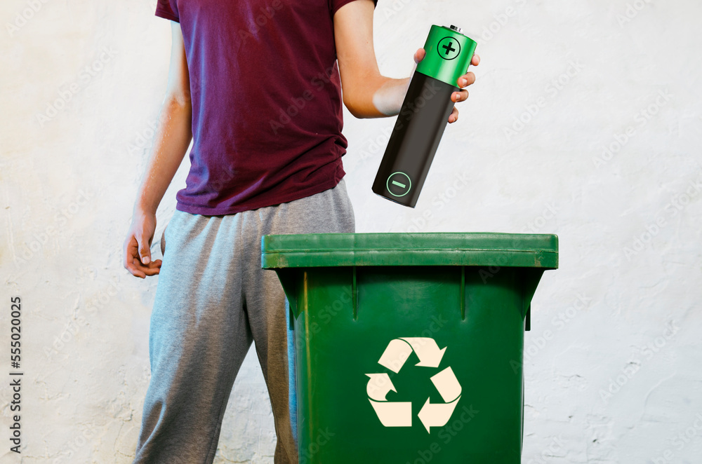 AA battery recycling concept, phot manipulated image. man holding big