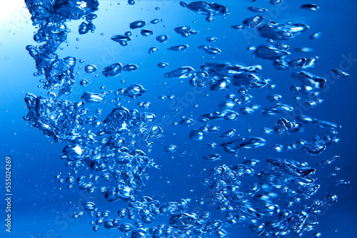Drops of water falling into deep blue water