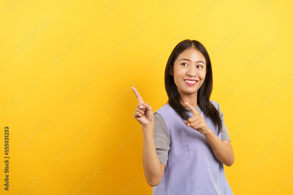 Young women pointing side to presenting something with empty space on isolated yellow background Young women pointing side to presenting something with empty space on isolated yellow background