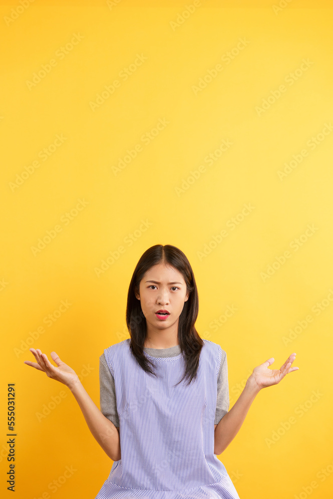 Young women making doubt face and open both hand with asking why on isolated yellow background Young women making doubt face and open both hand with asking why on isolated yellow background