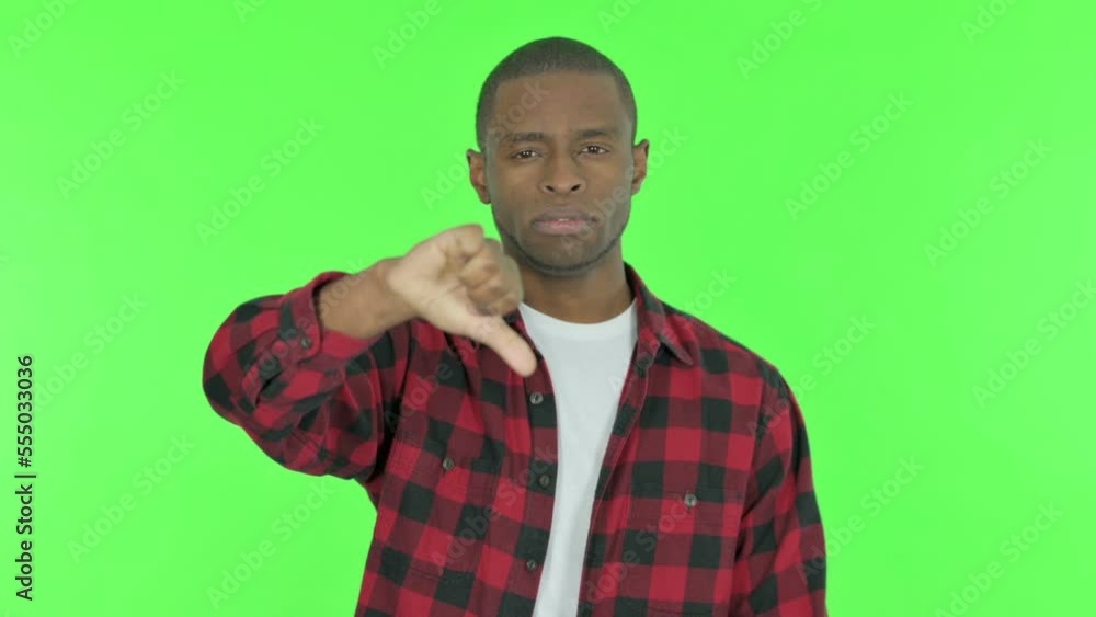 Thumbs Down by African Man on Green Background Thumbs Down by African Man on Green Background