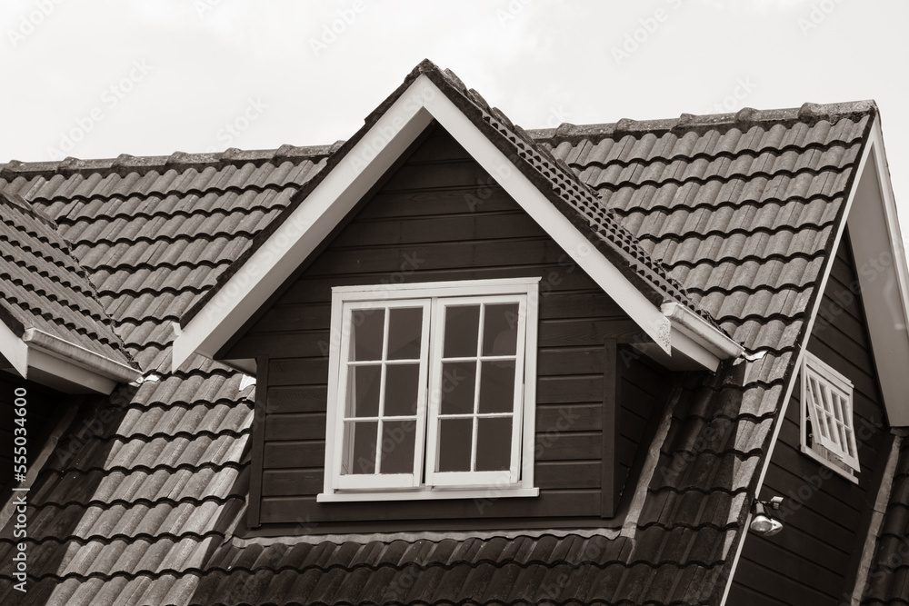 View of pitched roof dormer loft with white window and concrete tiles