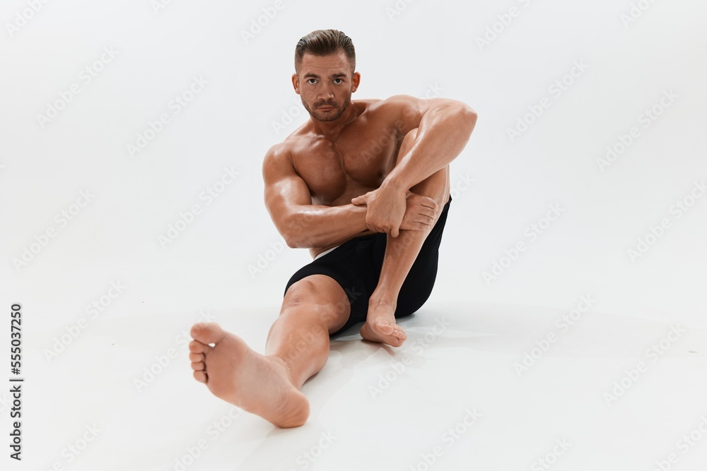 Obraz premium Man athletic body bodybuilder in briefs with naked torso abs full-length in the background, fitness classes. Advertising, sports, active lifestyle, competition, challenge concept.