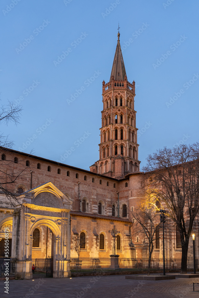 Vertical landscape view of ancient landmark St Sernin basilica illuminated in early evening, Toulouse, France