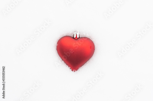 Heart shape Christmas bauble in snow for Valentines Day
