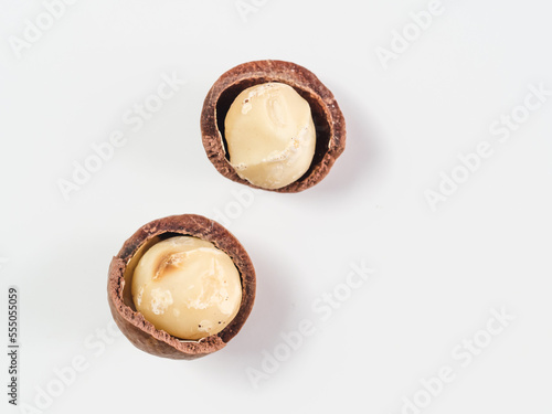 two macadamia nuts with open shells isolated