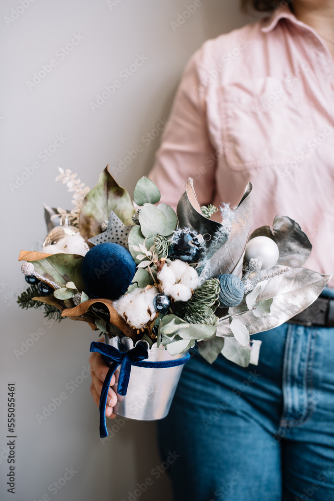 Very nice young woman holding beautiful winter composition of eucalyptus,  ornaments, nobilis spruce, cotton, in white green and blue colors, cropped  photo, bouquet close up Stock Photo | Adobe Stock