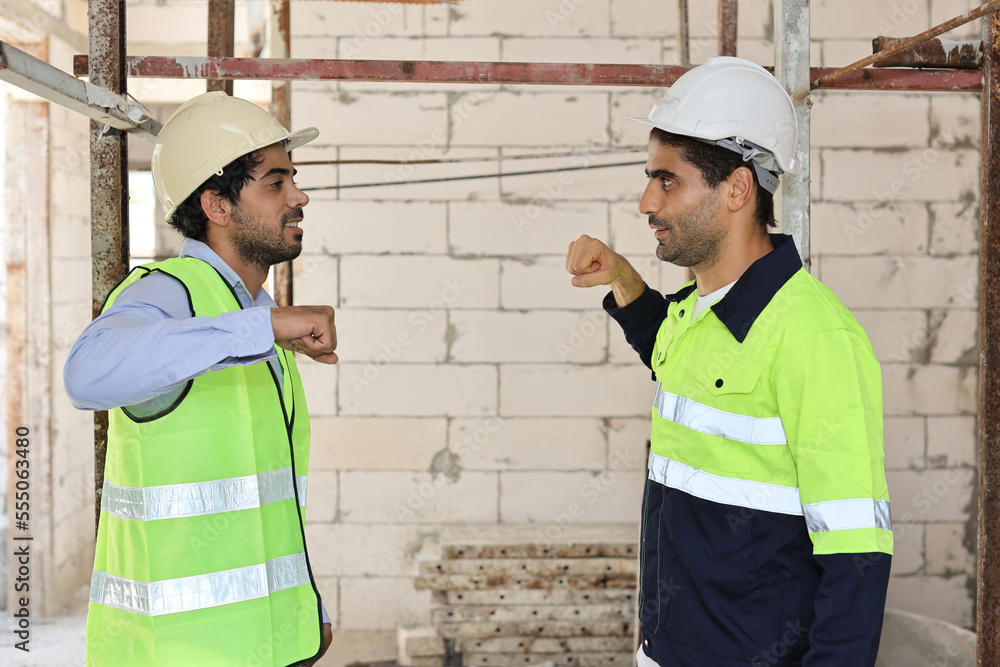Two technician civil engineer or specialist inspector making fist bumping celebrate successful together completed deal commitment at Industrial building site. Construction concept Two technician civil engineer or specialist inspector making fist bumping celebrate successful together completed deal commitment at Industrial building site. Construction concept