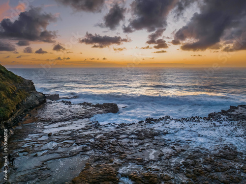 Surfs up sunrise at the seaside with scattered clouds