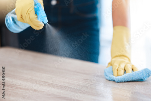Cleaning, housekeeping and hands with spray bottle on furniture for spring cleaning, dust and dirt on surface. Housework, healthcare and person with rubber gloves, cleaning products and disinfection