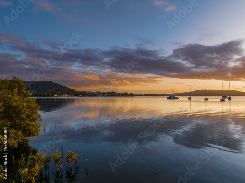 Aerial sunrise waterscape with boats  clouds and reflections