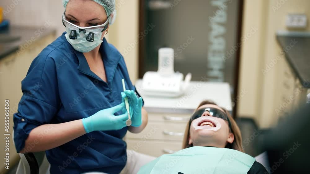 Woman lying on chair on tooth clinic with mouth dilator and
